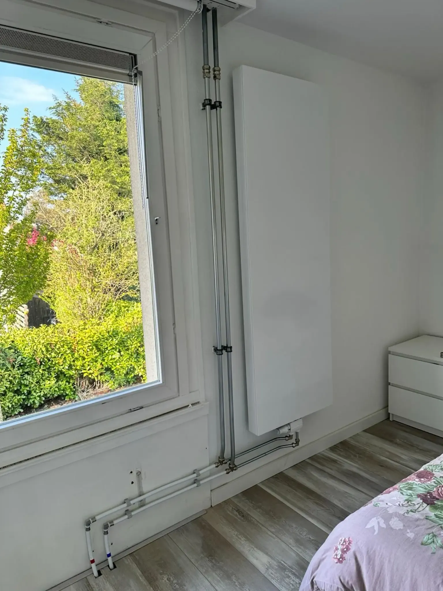 Verticale radiator geplaatst in slaapkamer